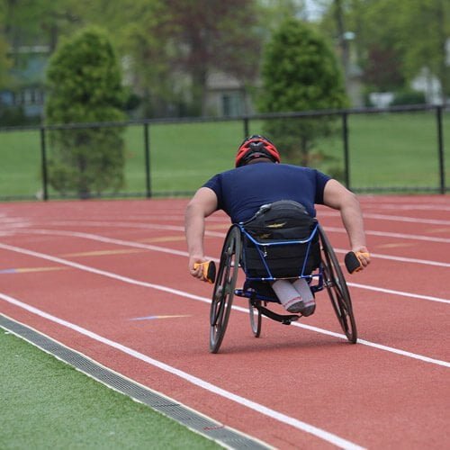 Man Racing Sports Wheelchair on Track